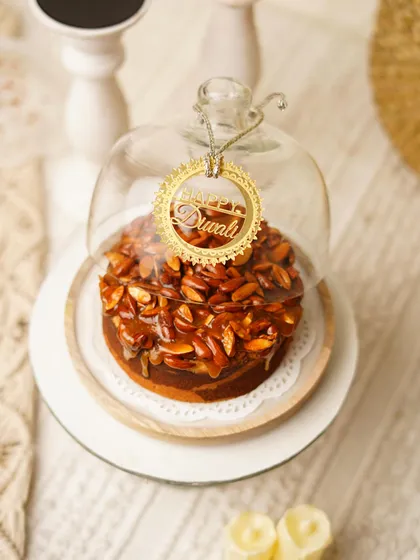 Our Almond Praline Teacake, specially dressed for Diwali. The reusable glass cloche makes it a gift that lasts long after the cake is gone.