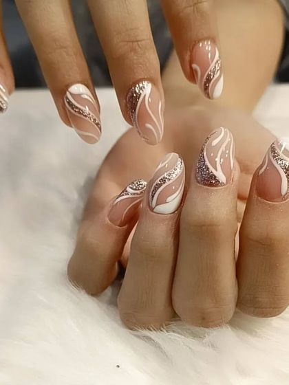 A beautiful abstract design with a nude base, white swirls, and sparkling silver glitter accents.