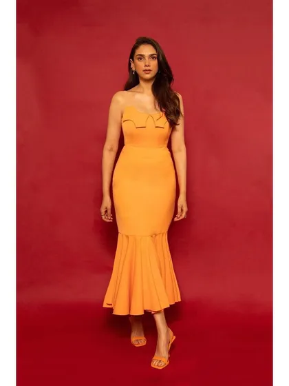 This orange strapless dress by RSR Riti Rahul Shah with a mermaid hem is a fun and flirty choice. The bright color and flattering cut make it perfect for a summer party.