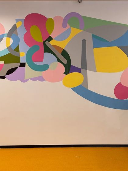A section of the completed abstract mural, showcasing the interplay of curved forms and a diverse color palette. The design brings a sense of movement and joy to the corporate environment.