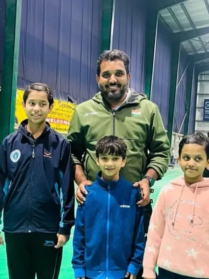 A group of young children posing with our expert panel coach, excited to start their badminton journey.