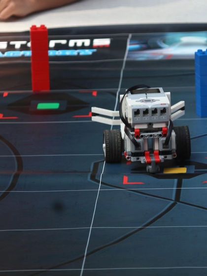 A LEGO Mindstorms robot positioned on a challenge mat during an IRO orientation. This demonstrates the type of advanced robotics our students learn to build and program.