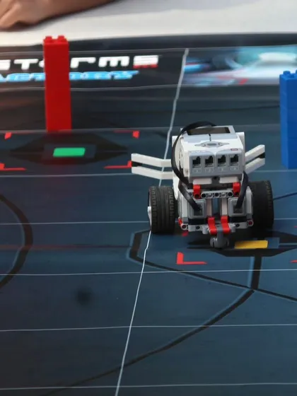 A close-up of a LEGO Mindstorms robot positioned on the competition mat during an IRO orientation. This is the type of advanced robot our students learn to build and program for high-level competitions.
