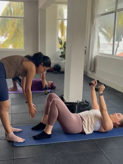 Here I am helping a client with her form during a chest lift with light dumbbells. I provide personalized attention in my group classes to ensure everyone is moving safely and getting the most out of each exercise.