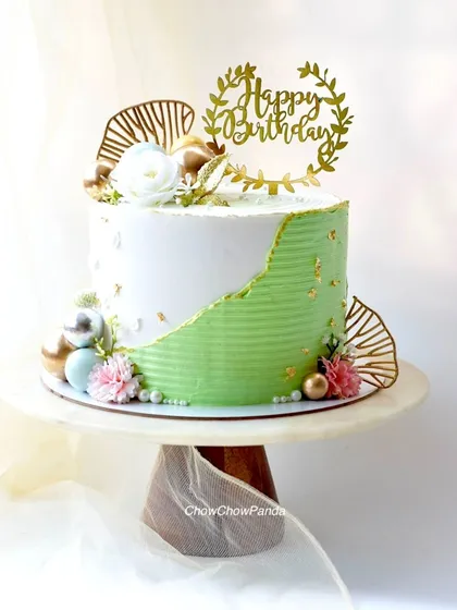 This is my take on the modern fault line cake trend. I used a combination of textured green and smooth white buttercream, highlighted with edible gold leaf for an elegant touch. It's a Choco Raspberry cake, perfect for a sophisticated birthday celebration.