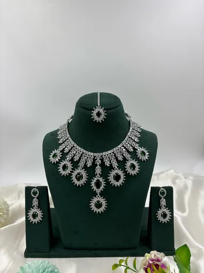Showcasing the modern side of our collection, this silver-plated American Diamond set features a unique sunburst design. It's available in multiple stone colors including white, black, and mint green, perfect for cocktail parties and contemporary tastes.
