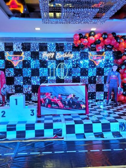 A closer look at the F1 racing theme, showing the checkered floor, sequin wall, and neon lighting that create an exciting race day atmosphere.