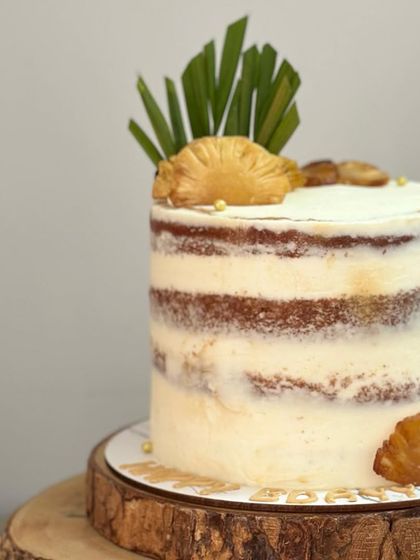 A closer look at the vintage-style semi-naked pineapple cake. The minimal frosting allows the texture of the cake layers to show through, creating a simple yet elegant aesthetic for a birthday celebration.
