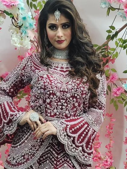 A model wearing the maroon peplum-style gown against a floral backdrop. This shows how the outfit can be styled for a party or reception.
