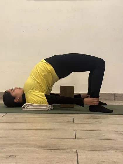 In this variation of Chatushpadasana, a block is placed between the thighs. This helps to engage the inner thigh muscles (adductors) and ensures the knees do not splay outwards, promoting better hip and knee alignment.