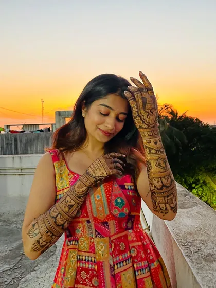 Shrutika enjoying a golden hour moment on the terrace, her mehendi glowing in the beautiful light.