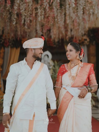 The bride and groom walking hand-in-hand, sharing a loving look under a beautifully decorated ceiling.