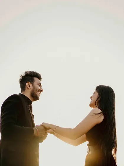 Holding hands against the bright, setting sun. This silhouette creates a simple yet powerful image about their connection and the bright future ahead of them.