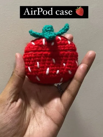 This custom-made crochet AirPod case is designed to look like a strawberry. It's a fun and unique way to protect your earphones.