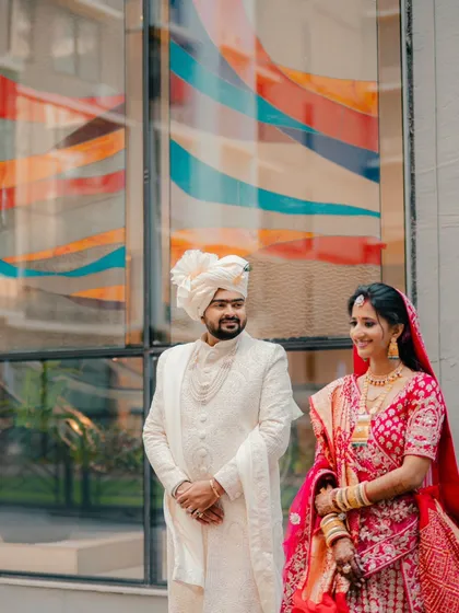 A simple and sweet portrait. The couple stands together, sharing a quiet moment and a gentle smile against a colorful background.