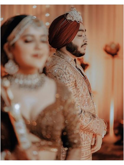 An artistic shot with the groom in a moment of quiet reflection, and the bride's soft focus image in the foreground.