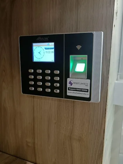 A close-up of the Realtime RS9 biometric device installed at the gym. It features a clear display and a responsive fingerprint scanner for quick authentication.