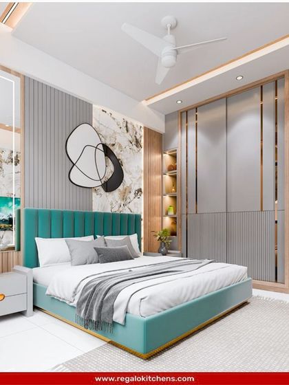 A bold and beautiful bedroom design. The wardrobe features clean lines and metallic gold accents that complement the teal upholstered bed frame, creating a vibrant, modern space.