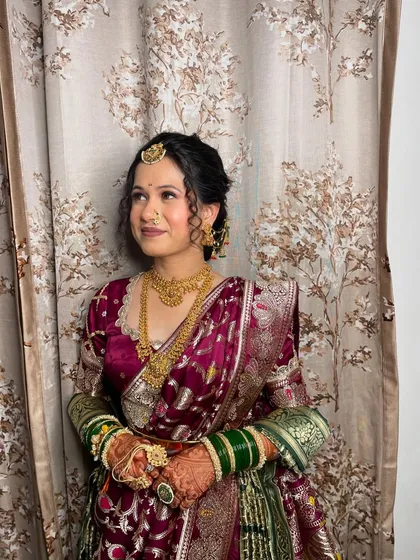 A side view of the traditional Marathi hairstyle, featuring a neat bun and delicate curls, perfect for her engagement ceremony.
