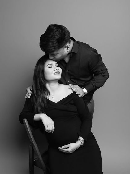 A tender black and white portrait. The classic forehead kiss is a timeless expression of love and care, beautifully captured in this simple, elegant shot.