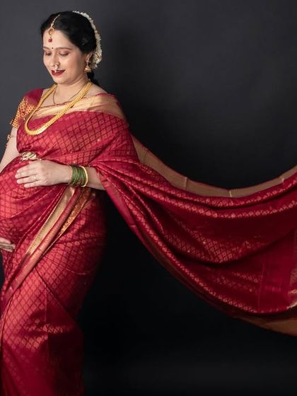 The flowing pallu of the saree adds beautiful movement to this shot. This is a simple yet stunning way to capture the grace of a mother-to-be in traditional attire.