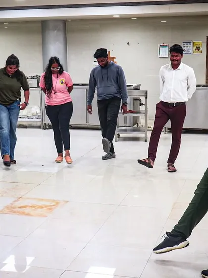 A coach demonstrates a coordination exercise to a group of employees. Our corporate sessions include a mix of fun drills that improve focus and teamwork.