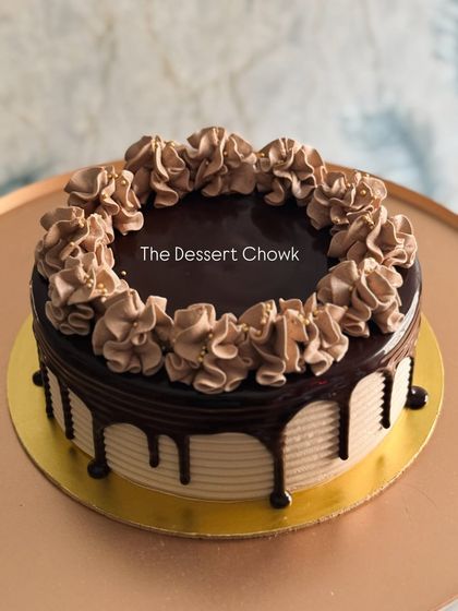 A classic chocolate drip cake with beautiful chocolate cream piping. A timeless choice for any celebration.