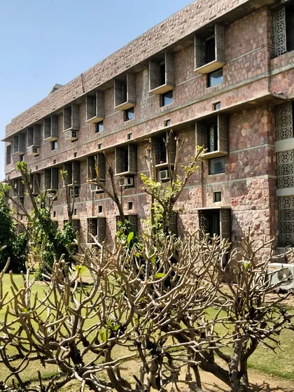 The building's facade showing deep-set windows and chajjas (shades). These passive design features are crucial in Rajasthan's climate, as they protect the interiors from harsh sun while allowing for natural ventilation.