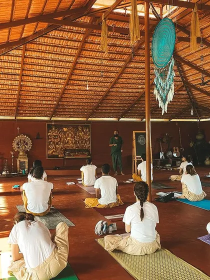 A wide shot of our yoga shala during a philosophy lecture. Students are seated, ready to absorb the teachings that form the foundation of their practice.