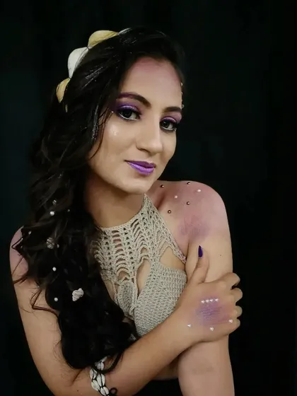 This shot highlights the body makeup details, including the pearls on the shoulder and the subtle purple shading that extends down the arm.