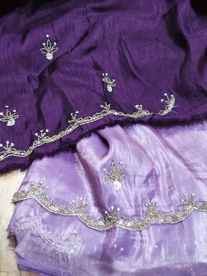 A gorgeous crush tissue saree in shades of purple with delicate self-colored embroidery. This lightweight and comfortable saree has a beautiful texture and a trendy, fashionable look.
