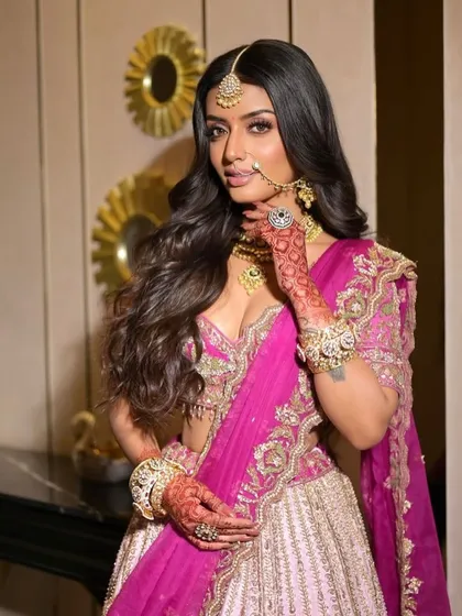 A confident pose showcasing the modern pink lehenga. The makeup is glamorous yet fresh, with a focus on glowing skin and eyes that pop.