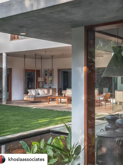 A covered veranda with a traditional Indian swing (jhoola) overlooking a central lawn and water feature. This design provides a classic, comfortable space for relaxation that is deeply connected to the outdoors.