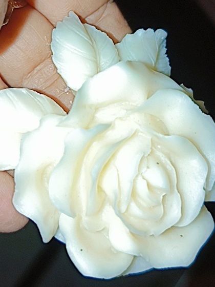 A close-up of a beautifully detailed white rose with leaves, made from one of my silicone molds. I can also create custom molds like this for your brand.