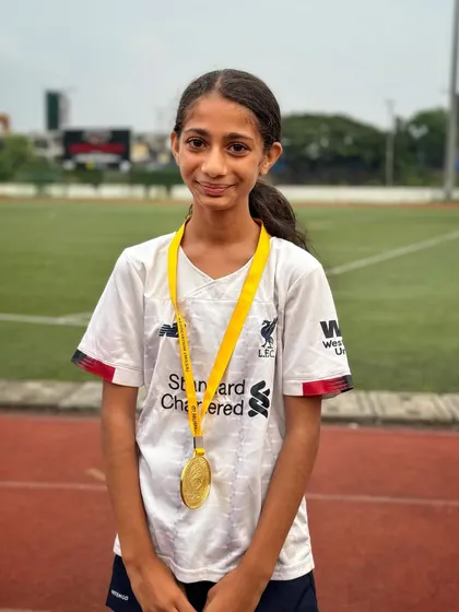 A gold medal winner right here. This young athlete's smile says it all after a successful day at the track.
