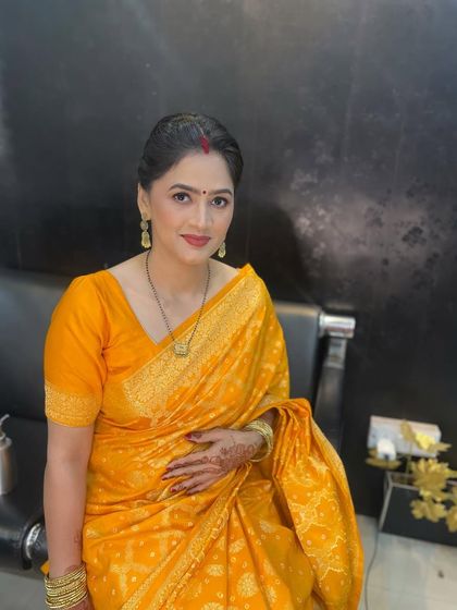 A full portrait of the client in her yellow saree, looking absolutely radiant.