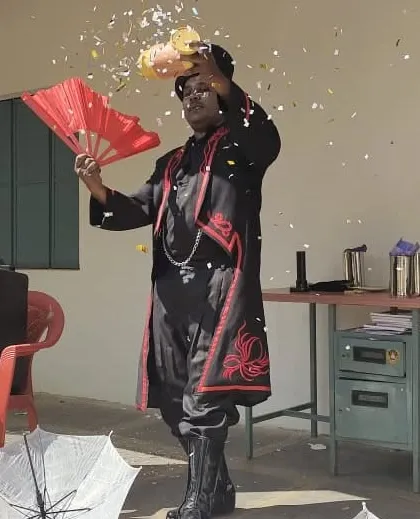 Using a traditional fan to add flair to a confetti illusion. The combination of classic props and surprising outcomes is what makes stage magic so entertaining.