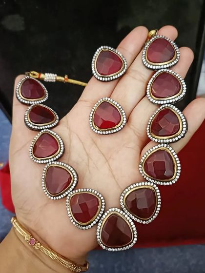 A bold Victorian-style necklace set with large triangular red stones. This is a unique rental piece for someone who wants to make a statement.