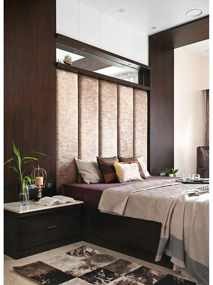 Another angle of the master bed, showing how the dark veneer paneling wraps around the headboard to create a cohesive, built-in look. The marble-topped side table adds a touch of classic elegance to the modern design.