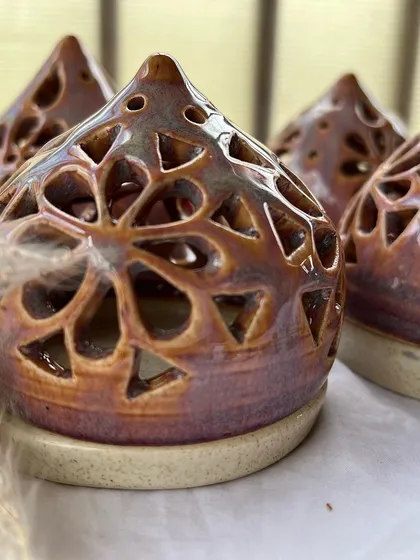 A close-up of my cone-shaped tea light holders. The glaze has a beautiful, iridescent quality that shimmers in the light.