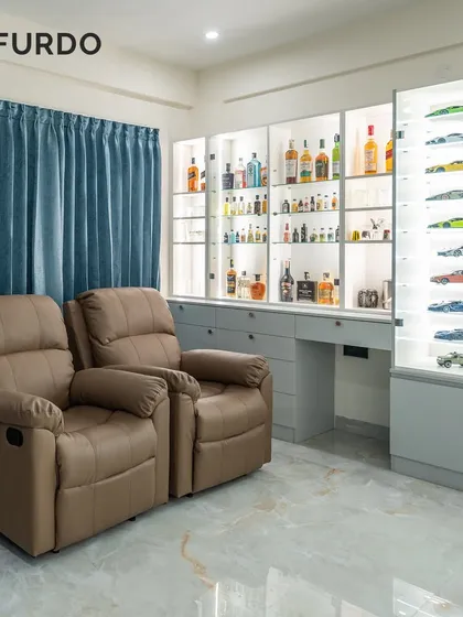 We create spaces that reflect your passions. This custom entertainment corner features comfortable leather recliners and bespoke, back-lit display cabinets, perfect for showcasing a prized collection of model cars and fine liquors.