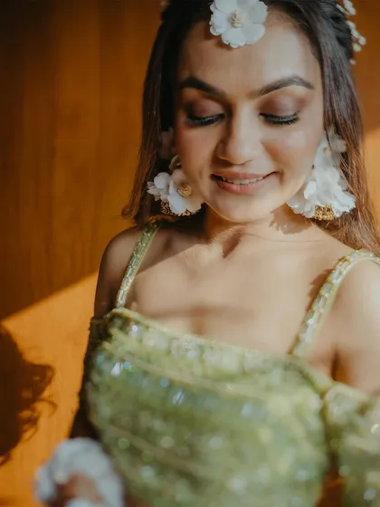 A close-up portrait of the bride, highlighting her delicate floral jewelry and the soft, natural light.