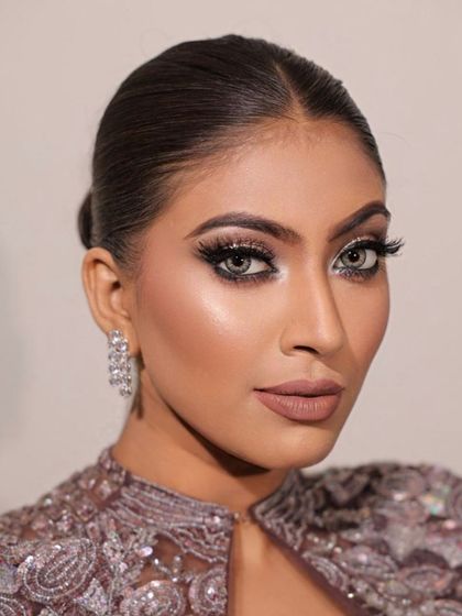 Embracing the spotlight with effortless glam. This look features a bold smokey eye and a sleek bun, perfect for a high-fashion reception or cocktail event.