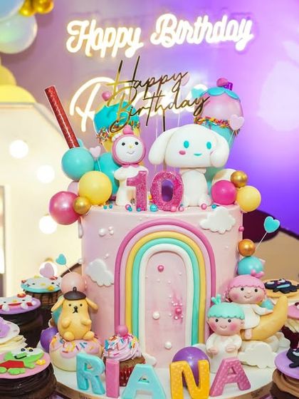 A stunning Hello Kitty birthday cake, adorned with characters, rainbows, and cupcakes, making it a delicious centerpiece.