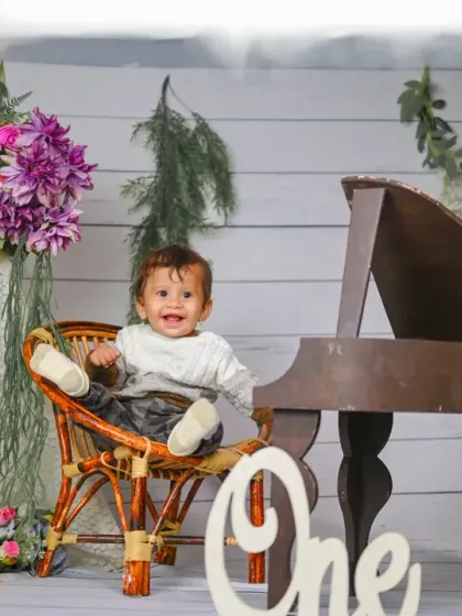 Celebrating ONE! This elegant setup with a miniature piano and floral details is a beautiful way to mark a first birthday.