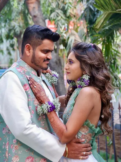 A romantic couple's portrait from their Haldi day. The bride's unique green and purple theme is reflected in her makeup and floral jewelry, creating a cohesive and beautiful look.