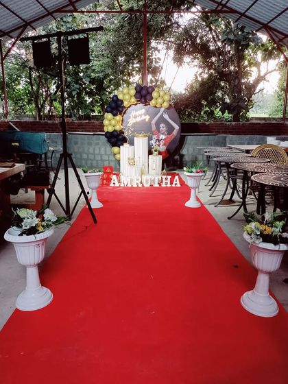 A birthday party entrance with a red carpet leading to a personalized backdrop. This setup creates a VIP experience for the birthday person and guests.