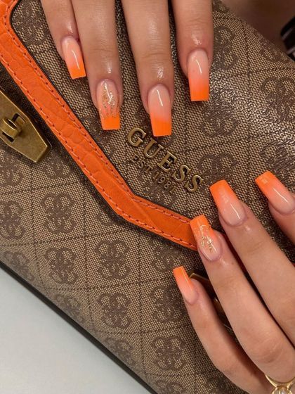 A bold and fiery sunset ombré with long, square-shaped extensions. The vibrant orange fades into a soft nude base, with a touch of gold glitter for extra flair.