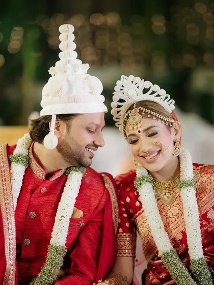 A close-up of the happy couple in their traditional Bengali wedding headwear, the 'topor' and 'mukut'. We pay close attention to cultural details.