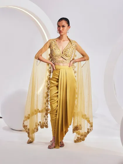 The LYDIA Cape Set, crafted from fine weaves and luxurious textiles. The set is an amalgamation of a breezy cape, an embellished blouse, and a pre-drape solid skirt.